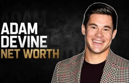 Adam Devine smiling in a checkered blazer