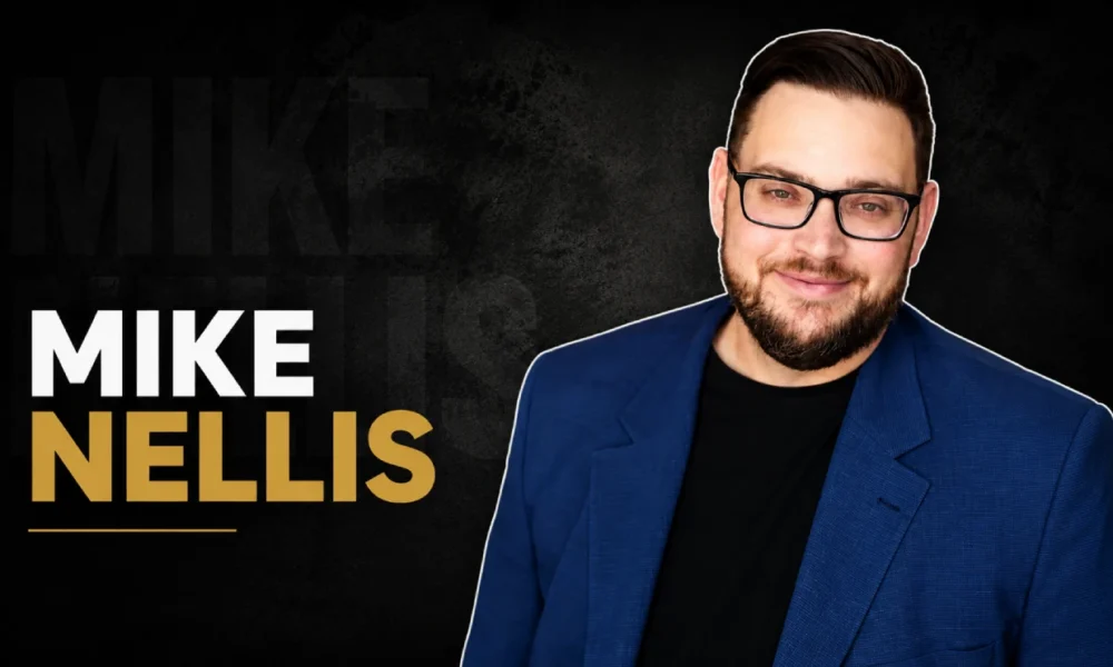 Mike Nellis in a blue blazer and glasses