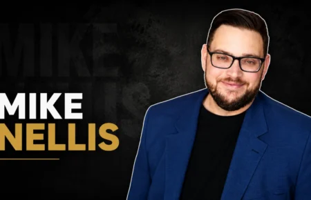 Mike Nellis in a blue blazer and glasses
