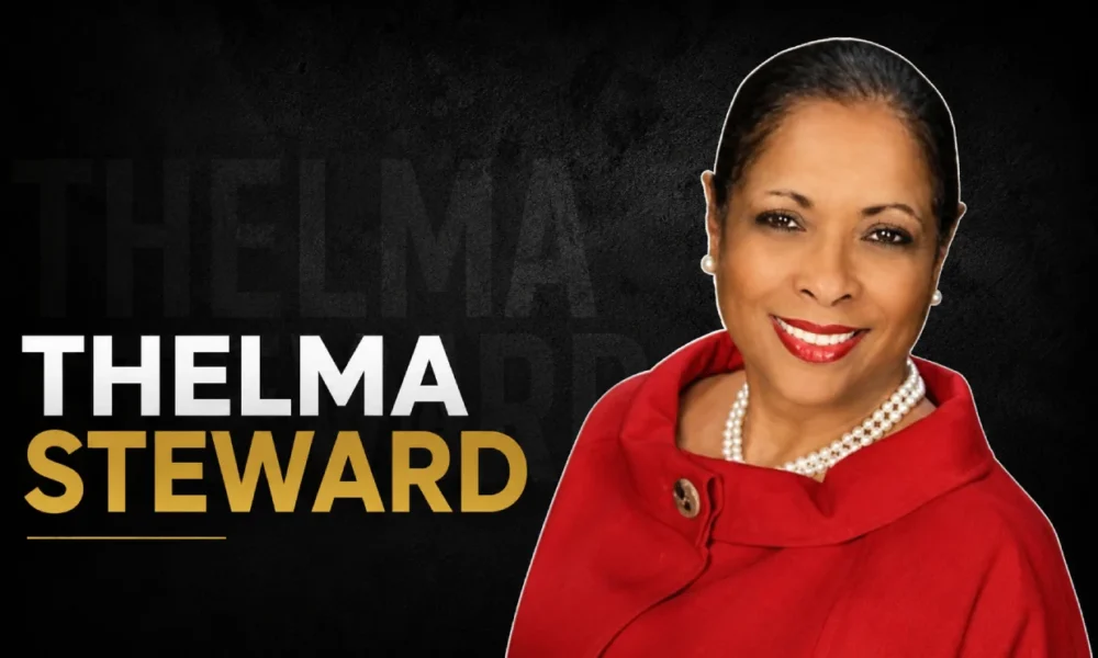 Thelma Steward wearing a red coat and pearl necklace