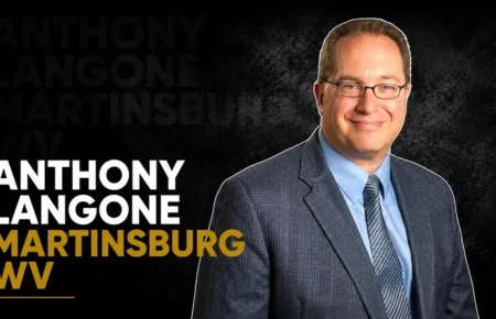 Anthony Langone wearing a suit and glasses