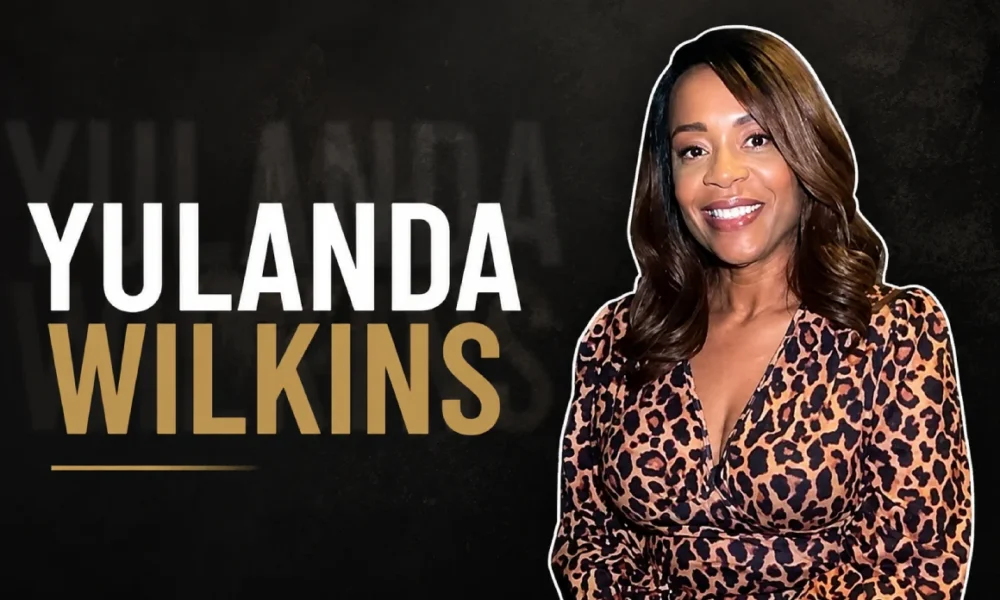 Yulanda Wilkins smiling while wearing a leopard print dress.