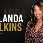 Yulanda Wilkins smiling while wearing a leopard print dress.